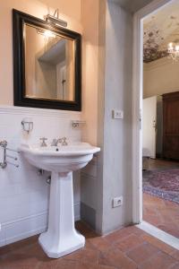 bagno con lavandino bianco e specchio di Locanda San Marco Residenza Caluri a Pistoia