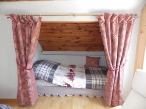 uma cama num quarto com cortinas em Au grenier du lac em Gérardmer