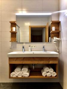 a bathroom with a sink and a mirror and towels at Ferienappartements Heinzle - Ihr Ferienresort in Sankt Jakob in Defereggen