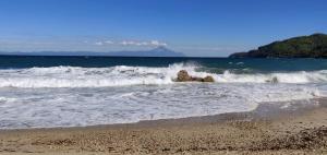 a beach with waves crashing on the shore at Kissos Apartments in Vourvourou