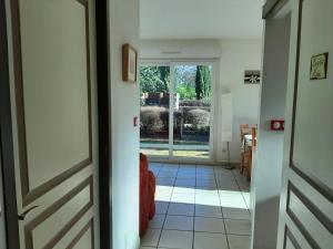 um corredor com uma porta e vista para um quintal em PURAVIDA APPART's em Lagnieu