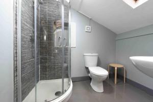 a bathroom with a shower and a toilet and a sink at Back Turner Townhouse in Manchester