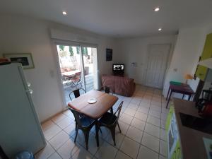 cocina y sala de estar con mesa y sillas en PURAVIDA APPART's en Lagnieu