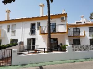 a white building with a fence in front of it at Casa Agnethe in Fuengirola