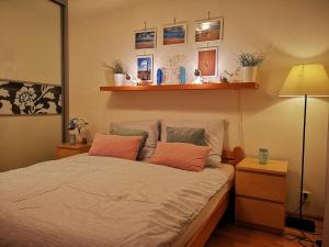 1 dormitorio con 1 cama con almohadas de color naranja y lámpara en Brunetti Design Zlín, en Zlín