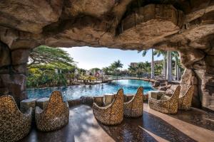 a row of leopard chairs in a pool at a resort at Lopesan Baobab Resort in Meloneras