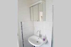 a white bathroom with a sink and a mirror at einfache zentrums nahe Wohnung in Gummersbach