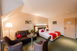 una camera d'albergo con letto e divano di Hotel am Fischerhafen a Ditzum