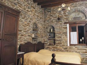 a bedroom with a stone wall with a bed at Anastasia Luxury Villas in Gavrio