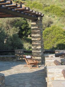 a wooden bench sitting under a stone wall at Anastasia Luxury Villas in Gavrio
