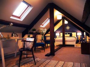 Schlafzimmer mit Oberlichtern, einem Bett und einem Stuhl in der Unterkunft Guestling Hall Hotel in Guestling