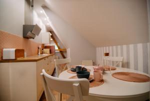 uma cozinha com uma mesa de jantar com cadeiras e uma cozinha com uma escada em Staszica16 em Złoty Stok