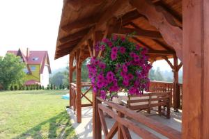 un cesto appeso di fiori rosa su un padiglione in legno di U Asi w Kotlinie Kłodzkiej - Widoki, Bania i Wiejskie Smaki a Bozkow