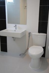 y baño con aseo blanco y lavamanos. en H12, The Stylish Apartment, en Hua Hin