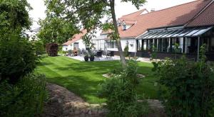 una casa con un patio verde con un edificio en Wanneshoeve, en Haacht