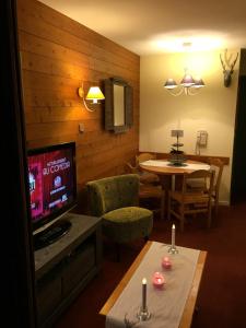 a living room with a television and a table with candles at Coquet studio Quartier Falaise superbe vue in Avoriaz