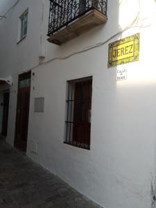 un panneau sur le côté d'un bâtiment avec un balcon dans l'établissement Carola GuestHouse, à Tarifa