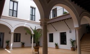 a courtyard with potted plants in a building at Apartamentos Fariñas 11 in Sanlúcar de Barrameda