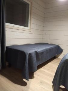 uma cama num quarto com uma janela em Louhi A em Äkäslompolo