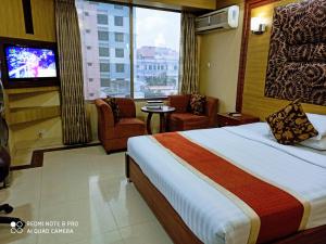 ein Hotelzimmer mit einem Bett und einem TV in der Unterkunft Marino Hotel - Best near Airport in Dhaka