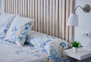 a bed with blue and white pillows and a lamp at Be&Ba Chinijo in Gran Tarajal