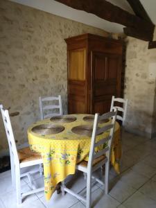 a table and chairs with a yellow table cloth on it at la petite peysie in Lisle