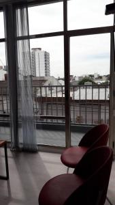 une chambre avec deux chaises et une grande fenêtre dans l'établissement DEPARTAMENTOS SAAVEDRA dto 3 y 4, à Viedma
