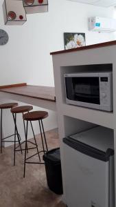 une cuisine avec un comptoir, un four micro-ondes et des tabourets dans l'établissement DEPARTAMENTOS SAAVEDRA dto 3 y 4, à Viedma
