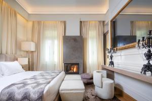 a hotel room with a bed and a fireplace at 3 Sixty Hotel & Suites in Nafplio