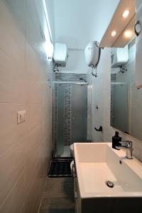 ein Bad mit einem Waschbecken, einer Dusche und einem Spiegel in der Unterkunft La magia del mare in Giovinazzo