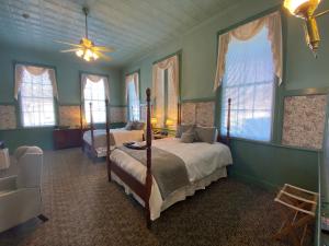 a bedroom with two beds and a fan and windows at Chambery Inn in Lee