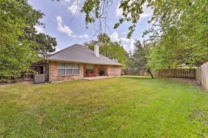 a brick house with a fence and a yard at Cozy College Station Home with Patio and Fireplace in College Station