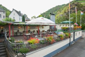 a restaurant with flowers on the side of a building at Alte Weinstube Burg Eltz in Treis-Karden