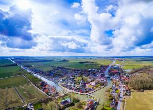 an aerial view of a town next to a river at Molen Hunsingo in Onderdendam