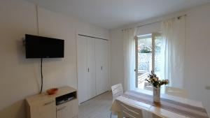 ein Wohnzimmer mit einem Tisch, einem TV und einem Fenster in der Unterkunft Apartments Andreja in Pag