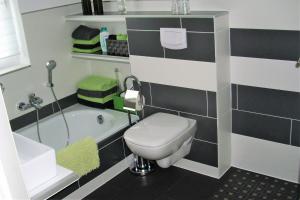 een badkamer met een toilet, een bad en een wastafel bij Seniorengerechte Ferienwohnung in Großalmerode in Trubenhausen