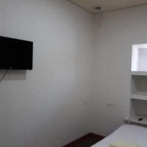 Habitación con TV de pantalla plana en una pared blanca. en Azimut en Jalal-Abad