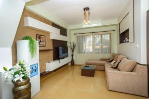uma sala de estar com um sofá e uma televisão em Feel Like Home Nepal em Catmandu