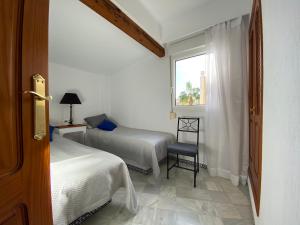 トレビエハにあるApartamento Tranquilo, Aldea del Marのベッドルーム1室(ベッド2台、窓付)
