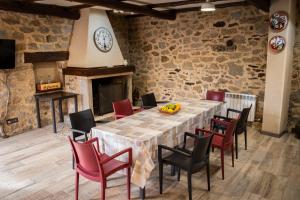 a dining room with a table and chairs and a clock at Casa Rural Castil de Cabras in San Miguel de Valero