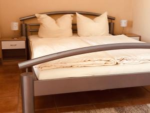 1 cama con marco de metal y sábanas y almohadas blancas en Landgasthof "Zum Schwarzen Roß" en Eichenzell