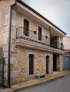 an old stone building with a balcony and stairs at Casa Rural Castil de Cabras in San Miguel de Valero