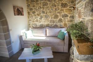 a living room with a couch and a stone wall at To Spiti mas in Sougia