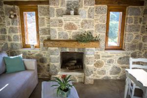 a living room with a stone wall with a fireplace at To Spiti mas in Sougia