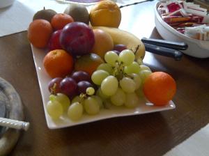 un plato de fruta en una mesa de madera en B&B A Casa di Mael, en San Costanzo