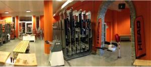 a room with a bunch of ski equipment on the wall at Teleo Vacanze - Villaggio Olimpico di Sestriere in Sestriere