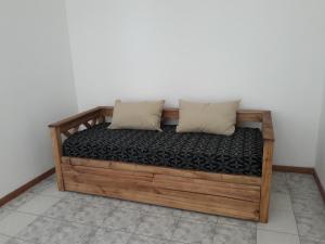 1 cama de madera con 2 almohadas en una habitación en CENTRO NORTE I con cochera incluida, en Bahía Blanca