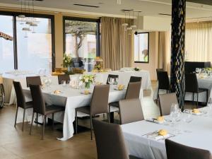 a dining room with white tables and chairs at K-Farm in Malo