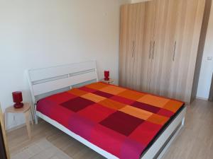 a bedroom with a bed with a colorful blanket on it at Emerald Buddha Apartment in Bansko