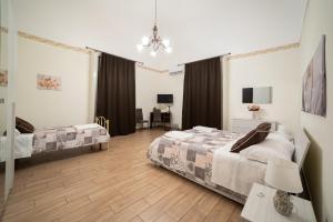 una camera con due letti e un tavolo con una sedia di Le Vie del Centro B&B a Catania